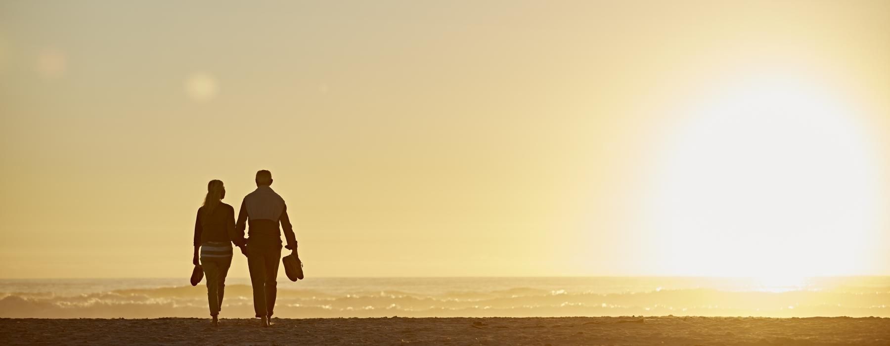 a man and woman walking on a beach